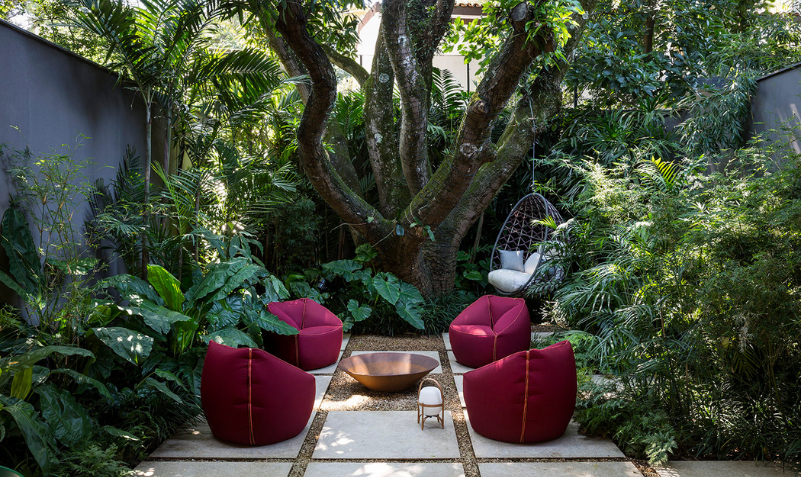 Un Espacio de Encuentro y Relajación Es evidente que la terraza del salón se ha convertido en un área central para la joven pareja que vive en esta casa, ya que disfrutan de recibir a amigos y familiares en este espacio. Este proyecto arquitectónico, diseñado por Jacobsen Arquitetura con el Diseño Paisajístico de Rodrigo Oliveira Paisagismo, gira en torno a un jardín central. Este enfoque no solo enriquece la disposición espacial entre los niveles de la vivienda, sino que también proporciona una abundante entrada de luz natural y ventilación a las distintas estancias. Las zonas sociales se ubican en la planta baja, conectadas a un jardín adicional en la parte posterior de la propiedad. En este entorno, se ha priorizado la integración de los diferentes espacios, eliminando barreras que antes aislaban el jardín interior.